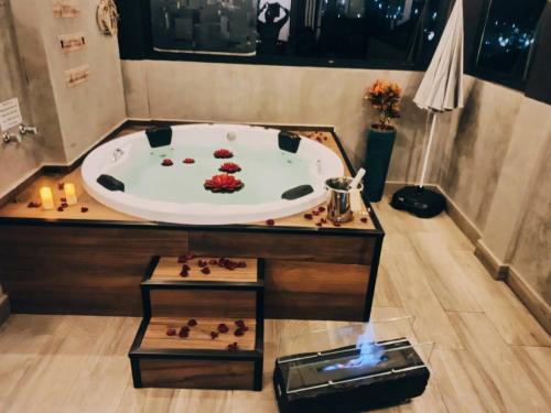 a bath tub in a bathroom with a sink at Uai House com jacuzzi (Espaço romântico) in Poços de Caldas