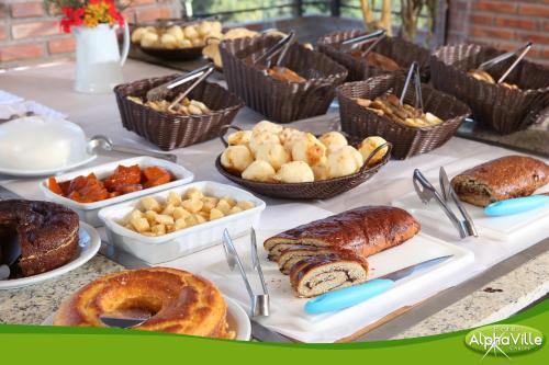 コンセイサオン・ダ・イビティポカにあるHotel Alpha Ville Chalésのパン菓子の種類が豊富なテーブル