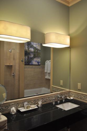 a bathroom with a sink and a large mirror at The Inn at Houmas House Estate in Darrow