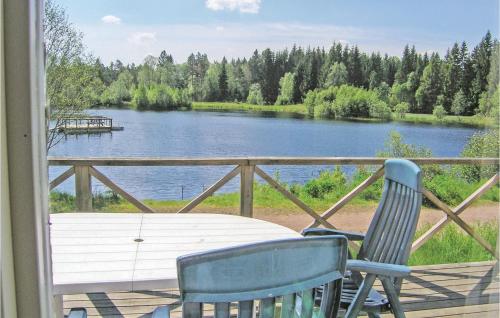 a porch with two chairs and a view of a lake at Three-Bedroom Holiday Home In Langaryd in Långaryd