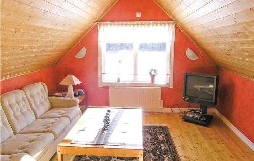 a living room with a couch and a tv at Three-Bedroom Holiday Home In Langaryd in Långaryd