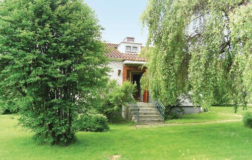 a house with a staircase in a yard with trees at Holiday Home Nöbblegatan Lenhovda in Lenhovda