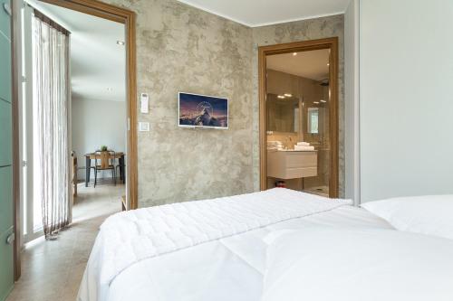 a bedroom with a white bed and a bathroom at Villa Velvet in Villeneuve-Loubet