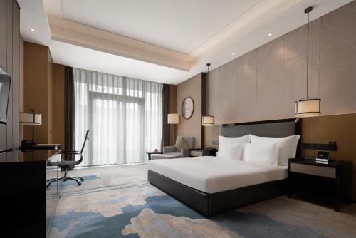 a hotel room with a bed and a large window at Wyndham Chongqing Yuelai in Chongqing