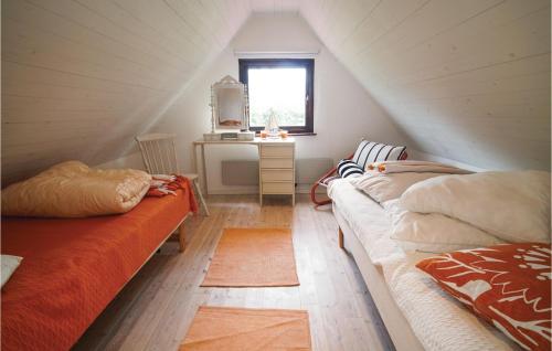 a attic room with two beds and a desk at 3 Bedroom Beautiful Home In Klagstorp in Klagstorp