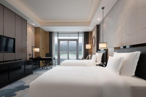 a hotel room with two beds and a television at Wyndham Chongqing Yuelai in Chongqing