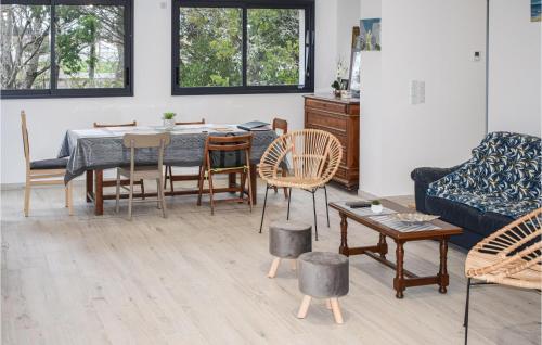 un salon avec une table, des chaises et un canapé dans l'établissement Stunning Home In Saint-Hilaire-De-Riez, à Saint-Hilaire-de-Riez