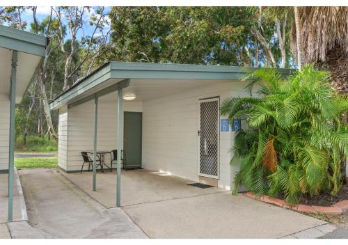 a small garage with a table and a chair in it at Discovery Parks - Tannum Sands in Tannum Sands