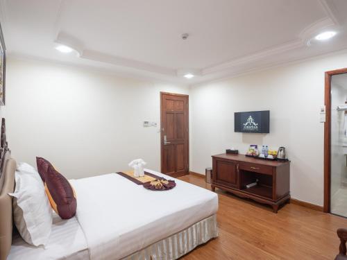 a bedroom with a bed and a wooden cabinet at Air Star Hotel in Ho Chi Minh City