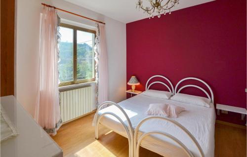 a bedroom with a white bed with a purple wall at Casa Di Cristian in Apecchio