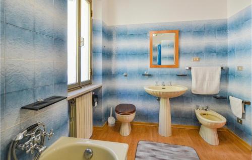 a blue tiled bathroom with a sink and a toilet at Casa Di Cristian in Apecchio