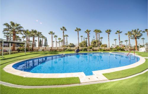 a large swimming pool in a resort with palm trees at Gorgeous Apartment In Oropesa Del Mar in Oropesa del Mar