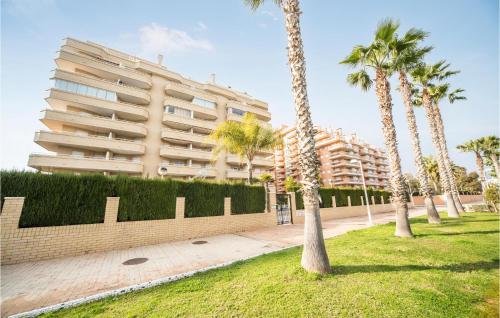 a park with palm trees and a building at Gorgeous Apartment In Oropesa Del Mar in Oropesa del Mar