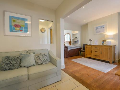 a living room with a couch and a bedroom at Beachcomber in Padstow