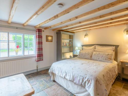 a bedroom with a large bed and a window at Gables Cottage in Market Rasen