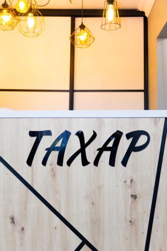 a sign that says taxi on a wooden wall at Hotel Tahar in Almaty
