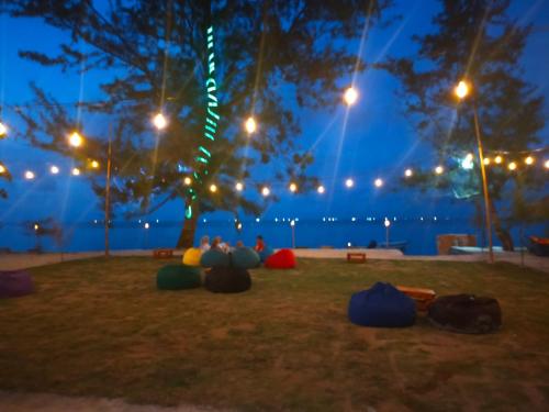 a group of people sitting under a tree at night at Madu Tiga Beach and Resort in Tanjung Pinang 