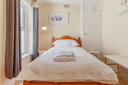 een slaapkamer met een bed met een handdoek erop bij Bay View in Brixham