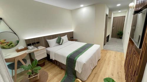 a bedroom with a bed and a desk with a mirror at 海的墾丁旅店 Ocean KT Inn in Kenting