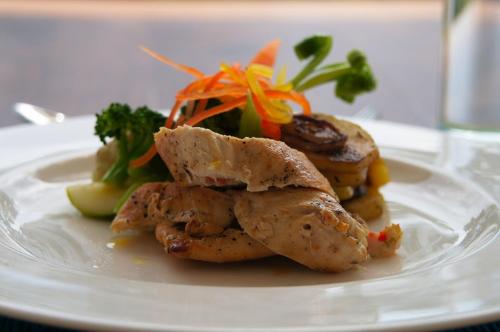 a plate of food with chicken and vegetables on a table at Niyagama House in Galle