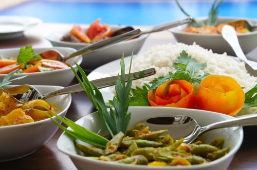 a table topped with bowls of different types of food at Niyagama House in Galle