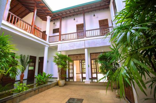 a courtyard of a house with palm trees at Niyagama House in Galle