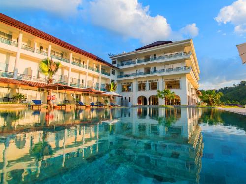 un hotel con piscina frente a un edificio en Katathong Golf Resort & Spa, en Phang Nga