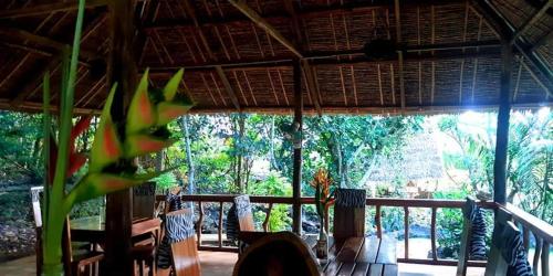 a room with a porch with a view of trees at Kim's Garden in Anda