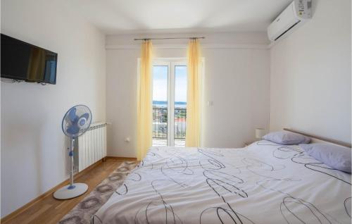 een slaapkamer met een bed, een ventilator en een raam bij Amazing Apartment In Podstrana With Wifi in Podstrana