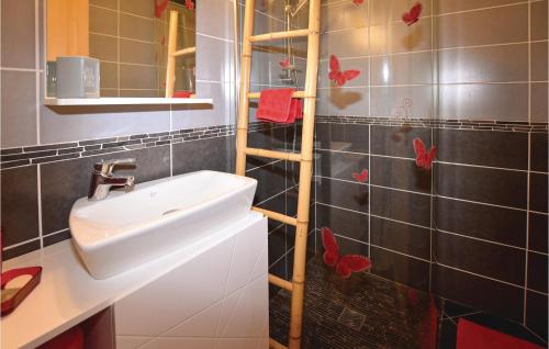 a bathroom with a sink and red butterflies on the wall at 4 Bedroom Gorgeous Home In Chamaret in Chamaret