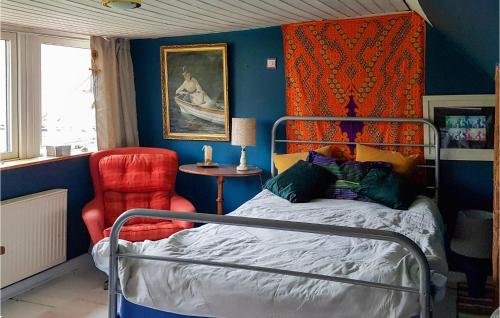 a bedroom with a bed and a red chair at Stunning Apartment In Östra Sönnarslöv in Östra Sönnarslöv