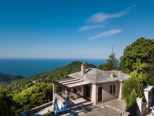 an aerial view of a house with the ocean in the background at A Dream Deferred villa Pelion in Kissós