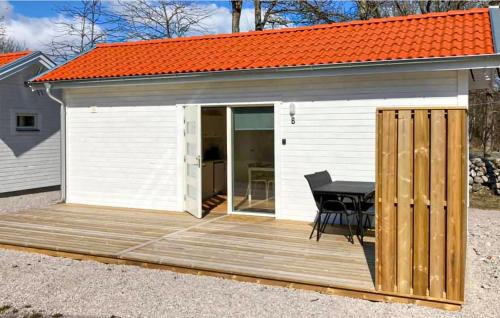 a wooden deck with a table and an orange roof at Lovely Home In Hasslö With Kitchen in Hasslö