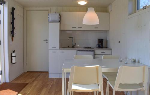 a kitchen with a white table and white chairs at Lovely Home In Hasslö With Kitchen in Hasslö