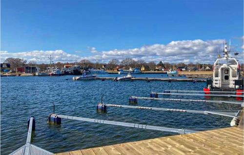 a marina with a dock and a boat in the water at Lovely Home In Hasslö With Kitchen in Hasslö