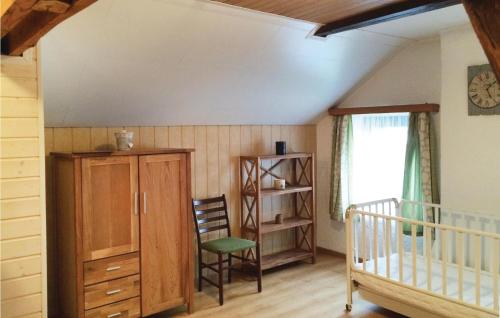 a room with a crib and a cabinet and a chair at Holiday Home Schönberg With Table Tennis 194 in Schoenberg