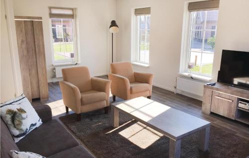 a living room with two chairs and a table and a tv at Buitengoed Het Lageveld - 83 in Hoge-Hexel