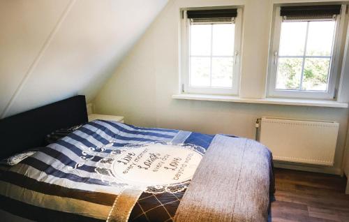 a bedroom with a bed and two windows at Buitengoed Het Lageveld - 83 in Hoge-Hexel