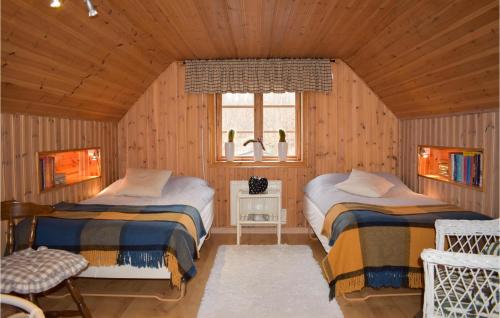 two beds in a wooden room with a window at Amazing Home In Johannishus With Wifi And 2 Bedrooms in Johannishus