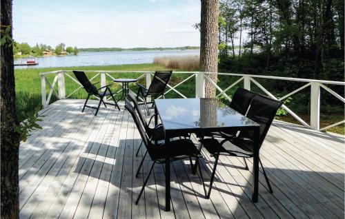 a table and chairs sitting on a deck next to a lake at 3 Bedroom Amazing Home In Strängnäs in Strängnäs