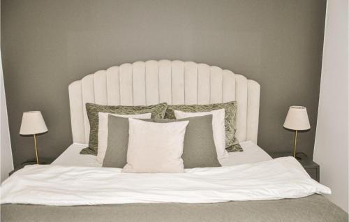a bedroom with a white bed with pillows and two lamps at 3 Bedroom Amazing Home In Strängnäs in Strängnäs