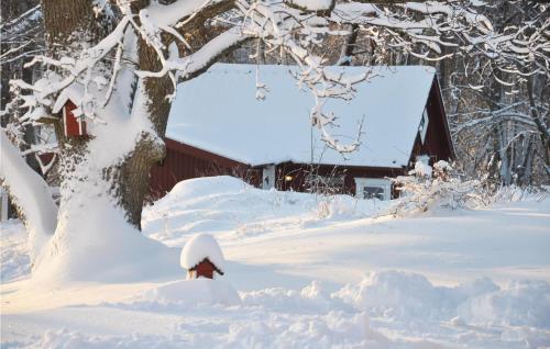 a fire hydrant covered in snow next to a barn at 3 Bedroom Amazing Home In Strängnäs in Strängnäs