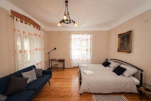 a living room with a bed and a blue couch at Apartment Island Country House in Savinja Valley in Žalec