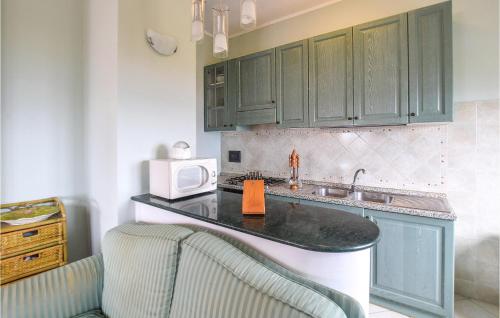uma cozinha com armários verdes, um lavatório e um micro-ondas em Lovely Apartment In Campo Calabro With House Sea View em Campo Calabro