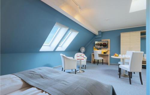 ダゲビュルにあるGorgeous Apartment In Dagebll With Wifiの青い壁のベッドルーム(白い椅子、テーブル付)
