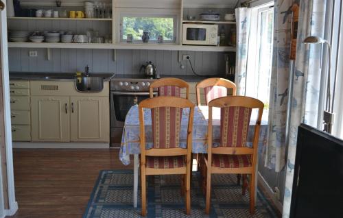 KorshamnにあるAmazing Home In Lyngdal With 3 Bedroomsのテーブルと椅子4脚付きのキッチン