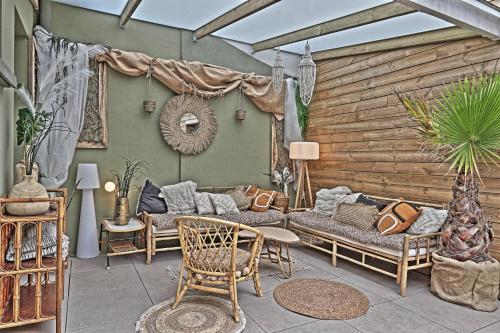 a patio with couches and a table and chairs at sangatte " Les Terrasses" maison front de mer Les pieds dans l'eau pleine de charme Cap Blanc Nez Côte d'Opale in Sangatte