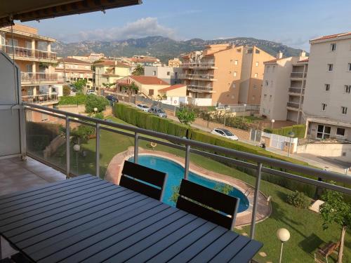 a balcony with a table and chairs and a swimming pool at Oliveres in Hospitalet de l'Infant