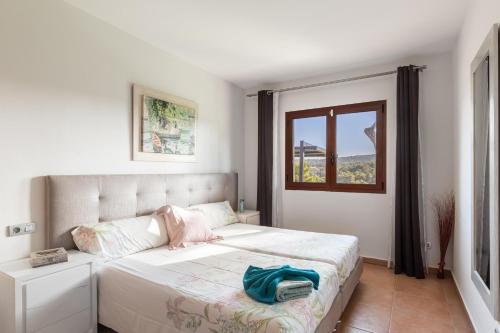 a bedroom with a large white bed with a window at Luxurious villa Sol de Mallorca in Sol de Mallorca