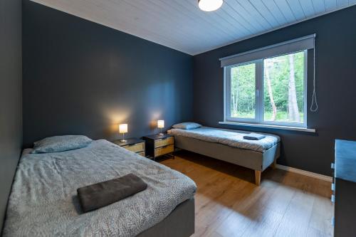 1 dormitorio con 2 camas y ventana en Jõeranna Pond House, en Jõeranna